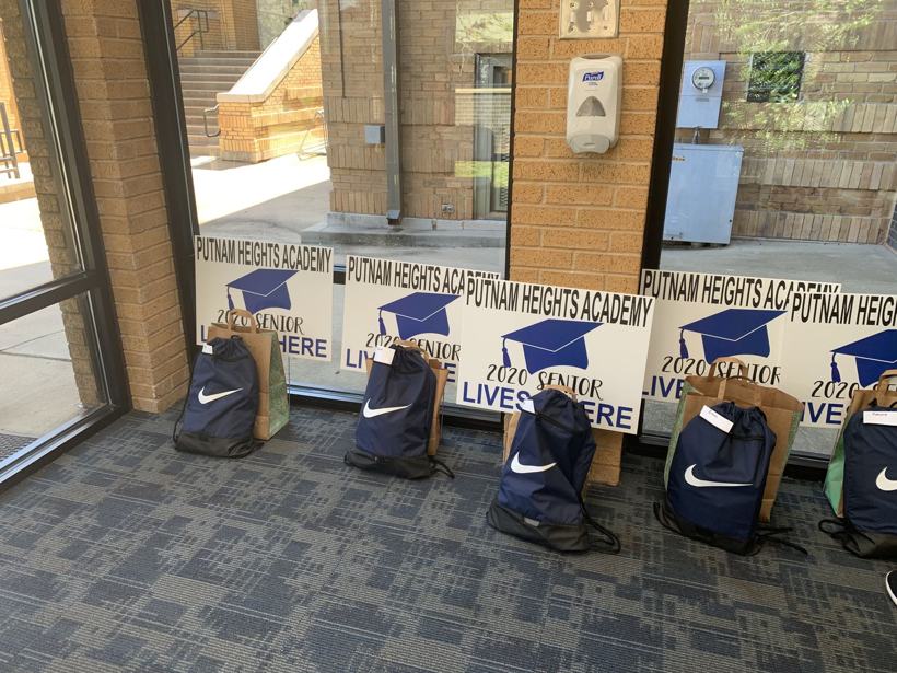 Graduation gift bags lined up with Senior Lives Here yard signs.