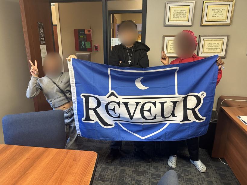 Students holding the Reveur house flag. Faces blurred.
