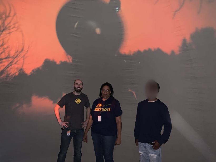 Staff and a student under the planetarium dome. Student face blurred.