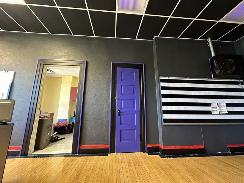 Science classroom with a black ceiling, purple trim, and a striped board.