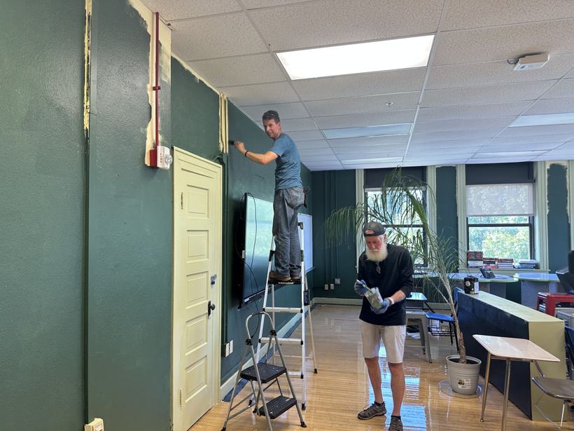 Volunteers painting the biology room deep green.