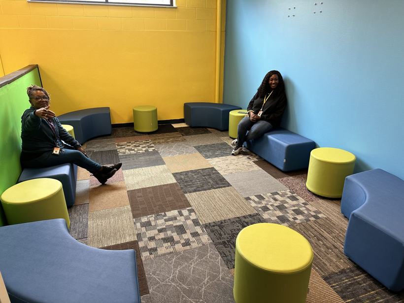 Counselors in a soft-seating nook with blue benches and lime ottomans.