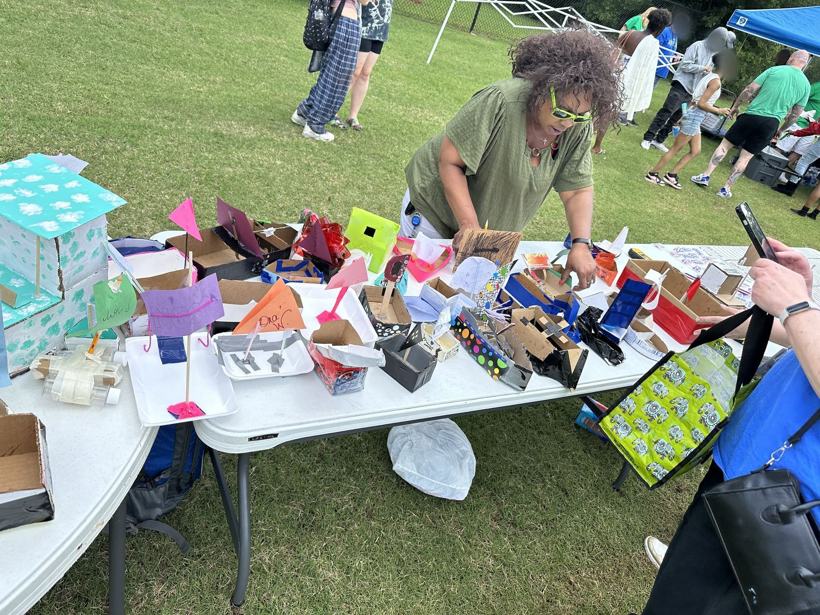 A table full of student-made ticket boats at the outdoor event.