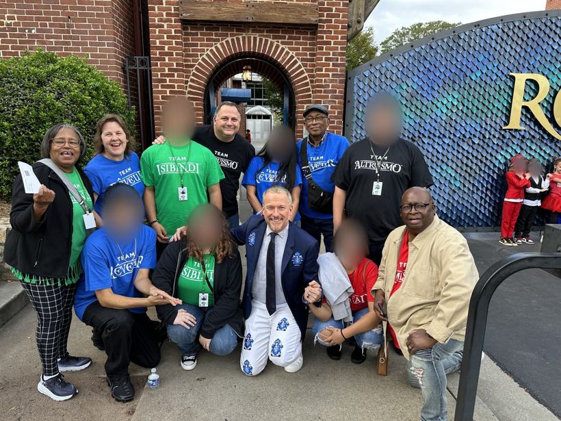 Students and staff in house shirts outside the Ron Clark Academy. Student faces blurred.