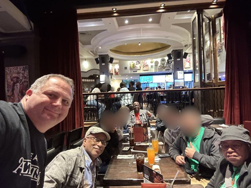 Group dinner selfie in Atlanta. Student faces blurred.